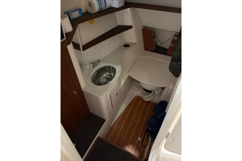  Yacht Photos Pics 2018 Grady-White Freedom 325 boat bathroom with sink, toilet, and wooden flooring.