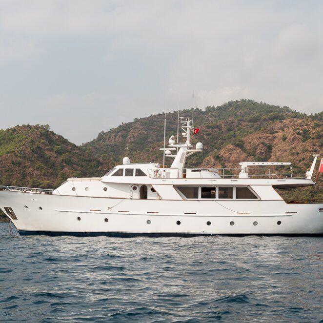 White Codecasa 26m yacht from 1984 on calm water, with scenic hills in the background.