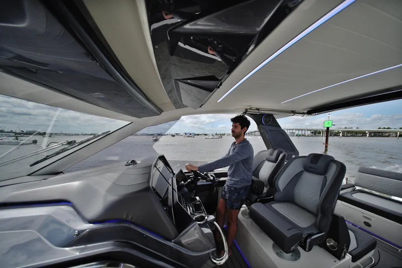  Yacht Photos Pics Man steering 2023 Galeon 400 XL yacht on open water, modern interior design.