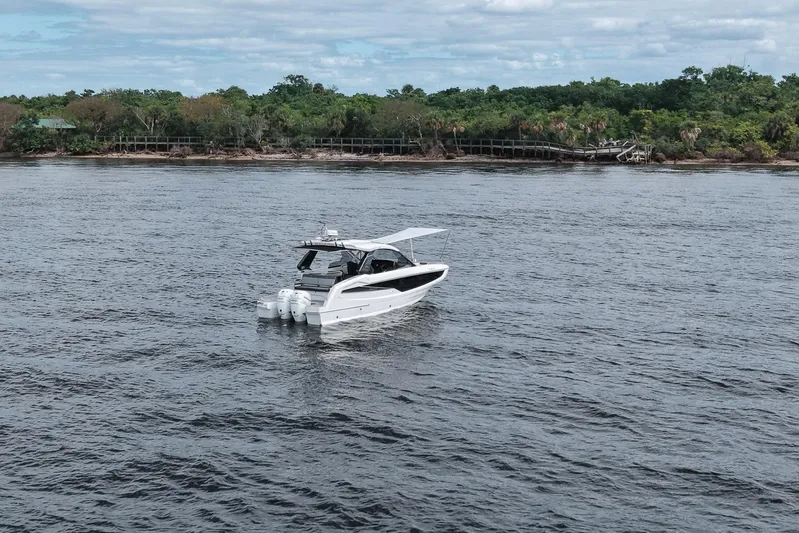  Yacht Photos Pics 2023 Galeon 400 XL yacht cruising on a serene river with lush green shoreline.
