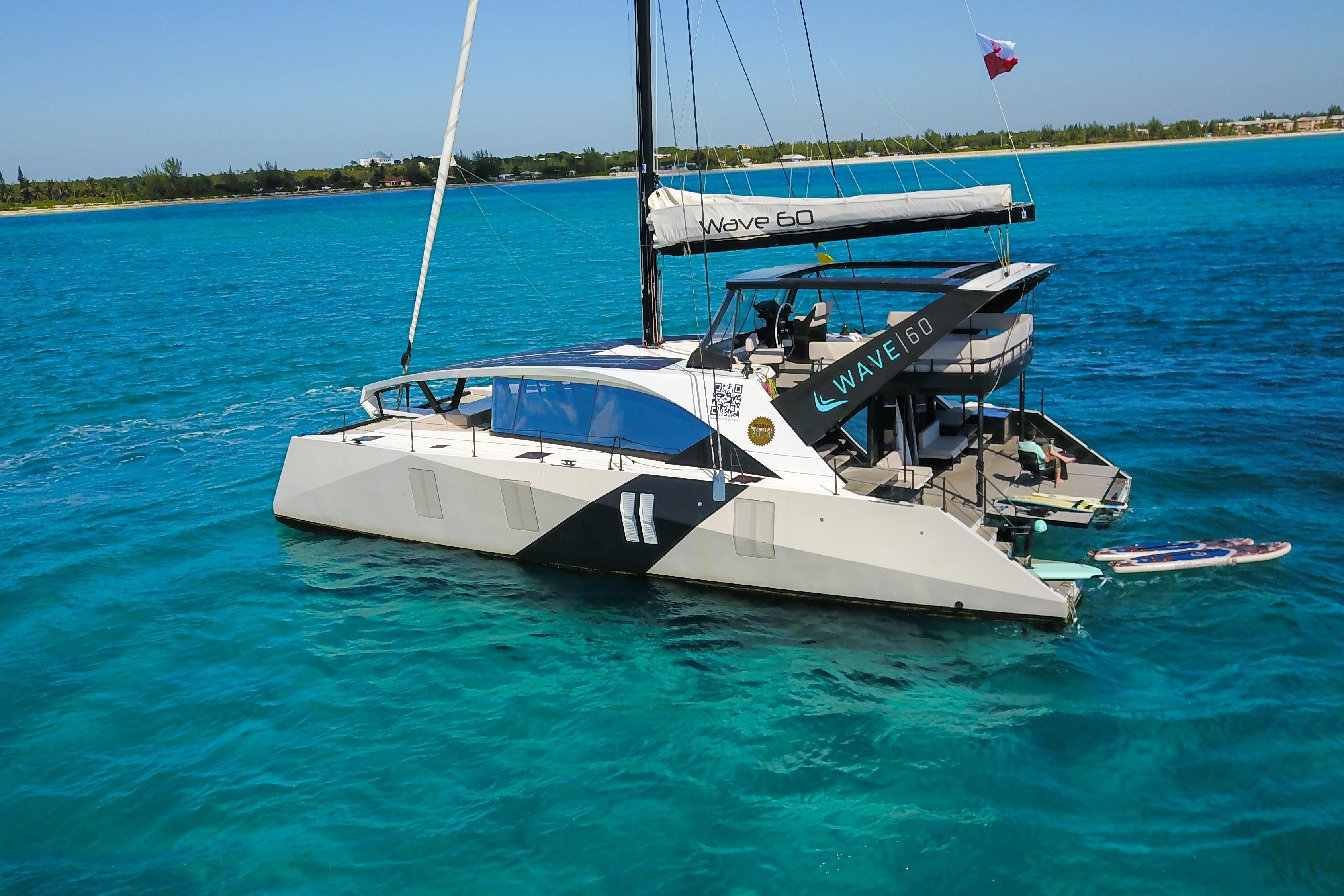 2024 Wave Wave60 catamaran sailing on clear turquoise waters.
