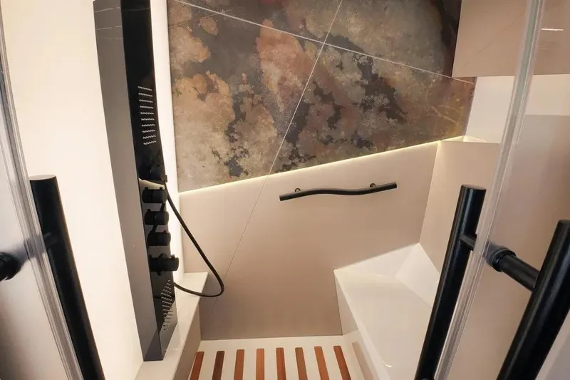  Yacht Photos Pics Luxurious Wave60 2024 shower interior with modern design and elegant stone-patterned wall.