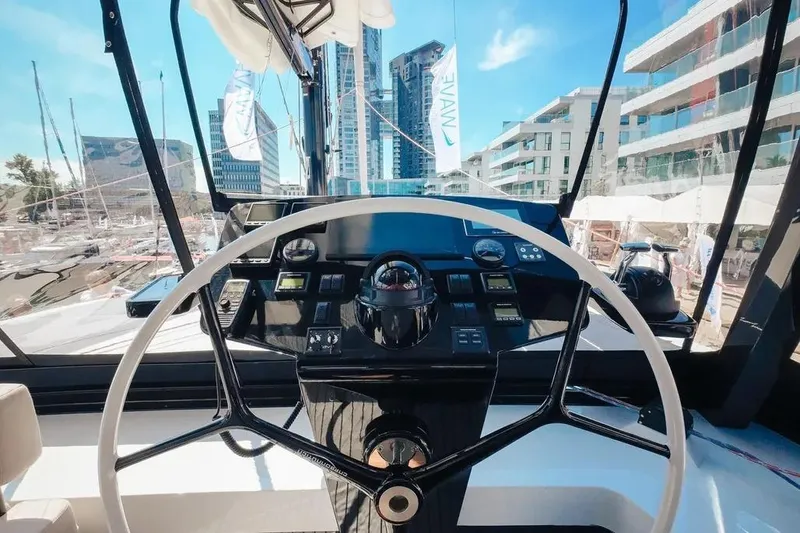  Yacht Photos Pics Steering wheel of 2024 Wave Wave60 yacht with modern dashboard and cityscape view.