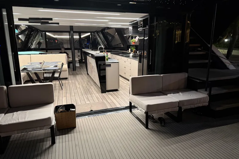  Yacht Photos Pics Luxurious 2024 Wave Wave60 yacht interior with modern kitchen and seating area at night.