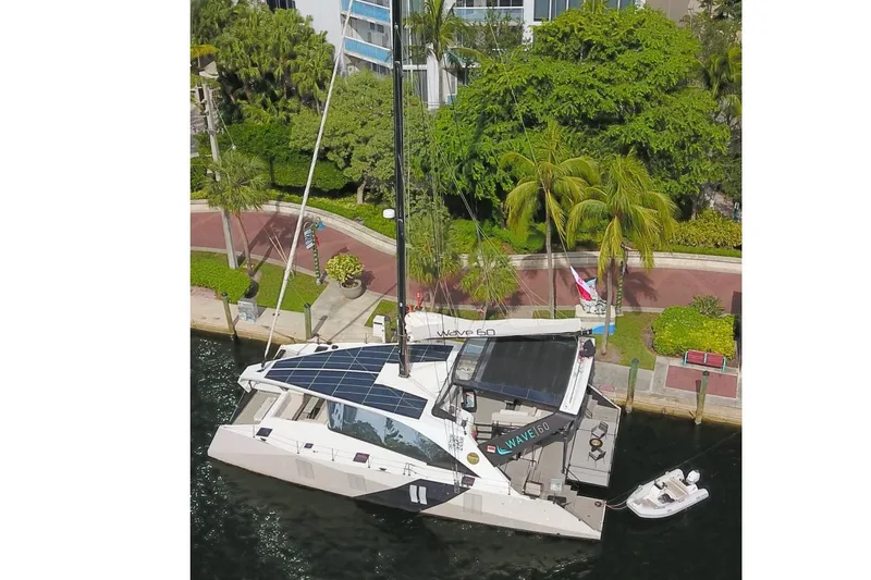  Yacht Photos Pics Aerial view of 2024 Wave Wave60 yacht docked, featuring solar panels and lush surroundings.