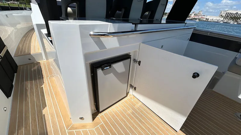  Yacht Photos Pics 2025 De Antonio Yachts D36 interior with open cabinet and mini fridge on deck.