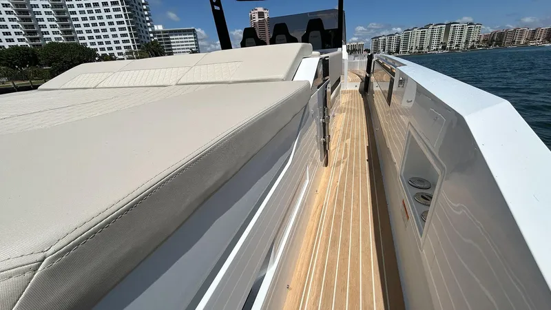  Yacht Photos Pics 2025 De Antonio Yachts D36 with sleek deck design, cruising near modern waterfront buildings.