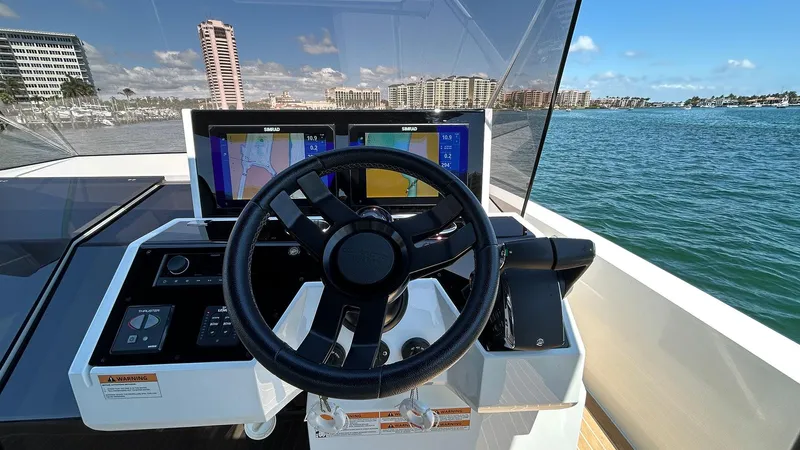  Yacht Photos Pics 2025 De Antonio Yachts D36 helm with navigation screens, steering wheel, and ocean view.