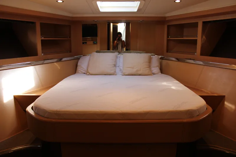 Happy Go Lucky Yacht Photos Pics Luxurious cabin interior of 2009 Riva SportRiva 56 yacht with cozy bed and elegant wood finish.