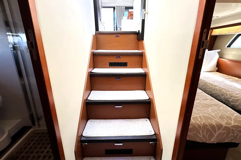 Eribella Yacht Photos Pics Staircase inside 2016 Prestige 500 S yacht, leading to upper deck, with adjacent bedroom.