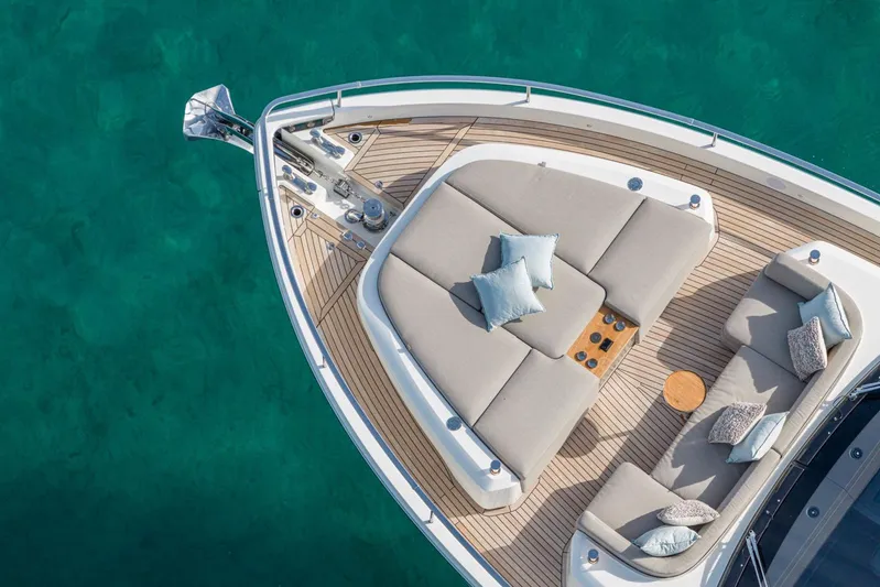  Yacht Photos Pics Luxurious 2026 Cranchi 62 yacht deck with plush seating and turquoise water backdrop.