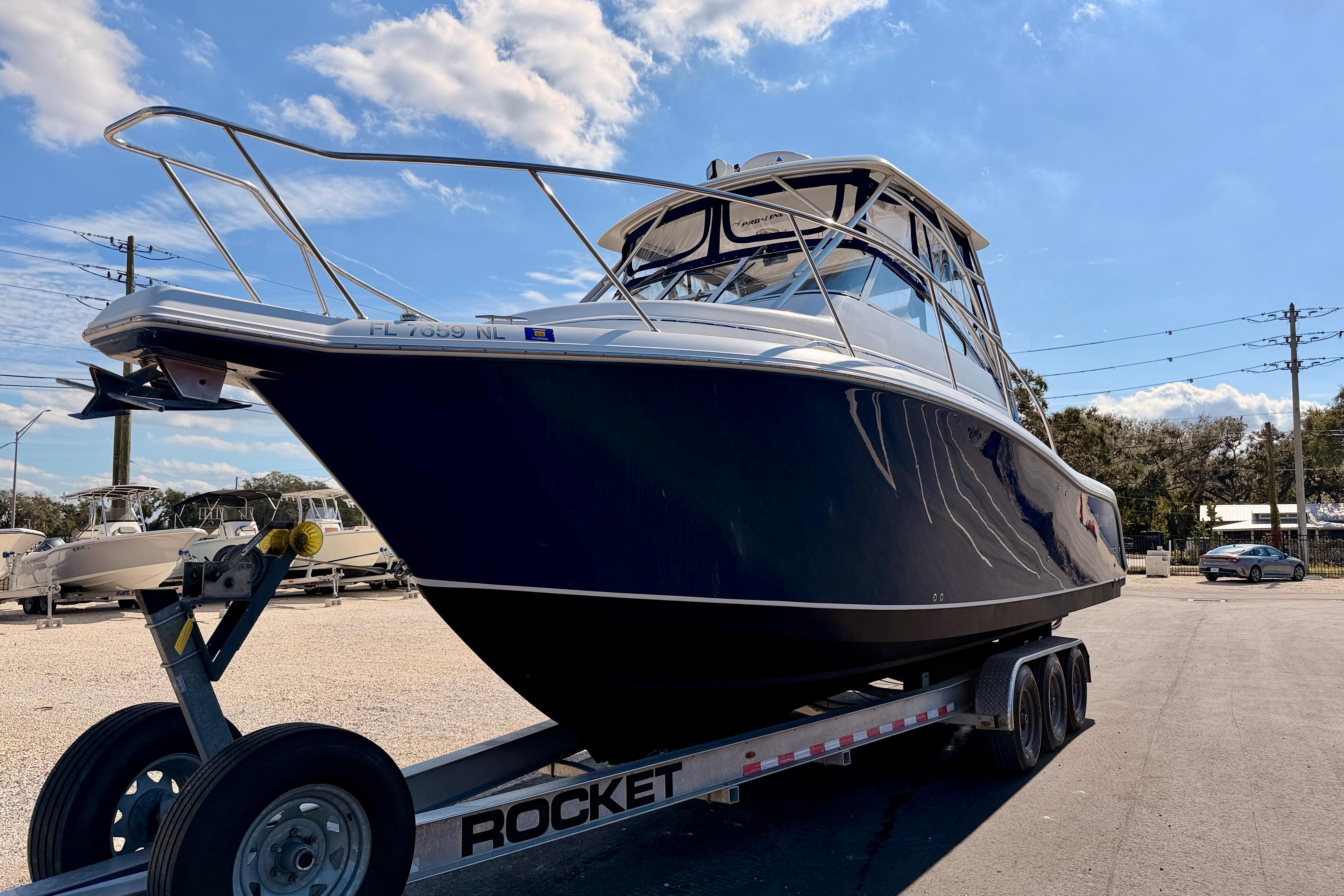 2007 Pro-Line 32 Express boat on trailer under clear blue sky.