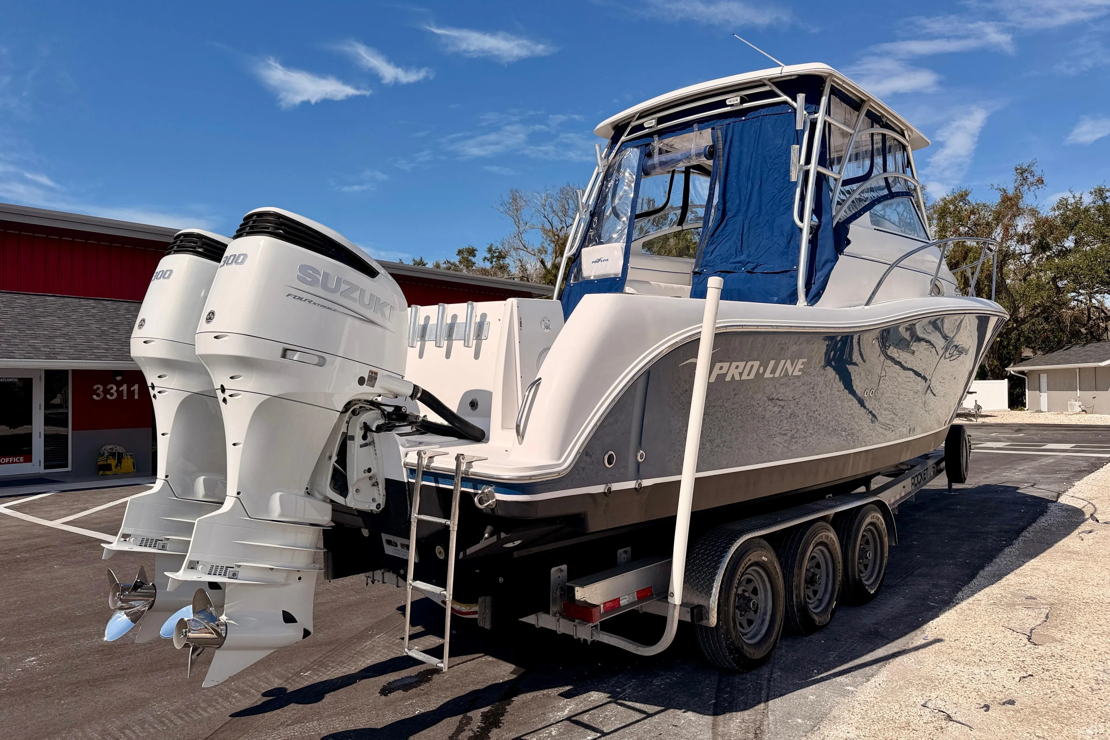2007 Pro-Line 32 Express boat with twin Suzuki outboard engines on a trailer.