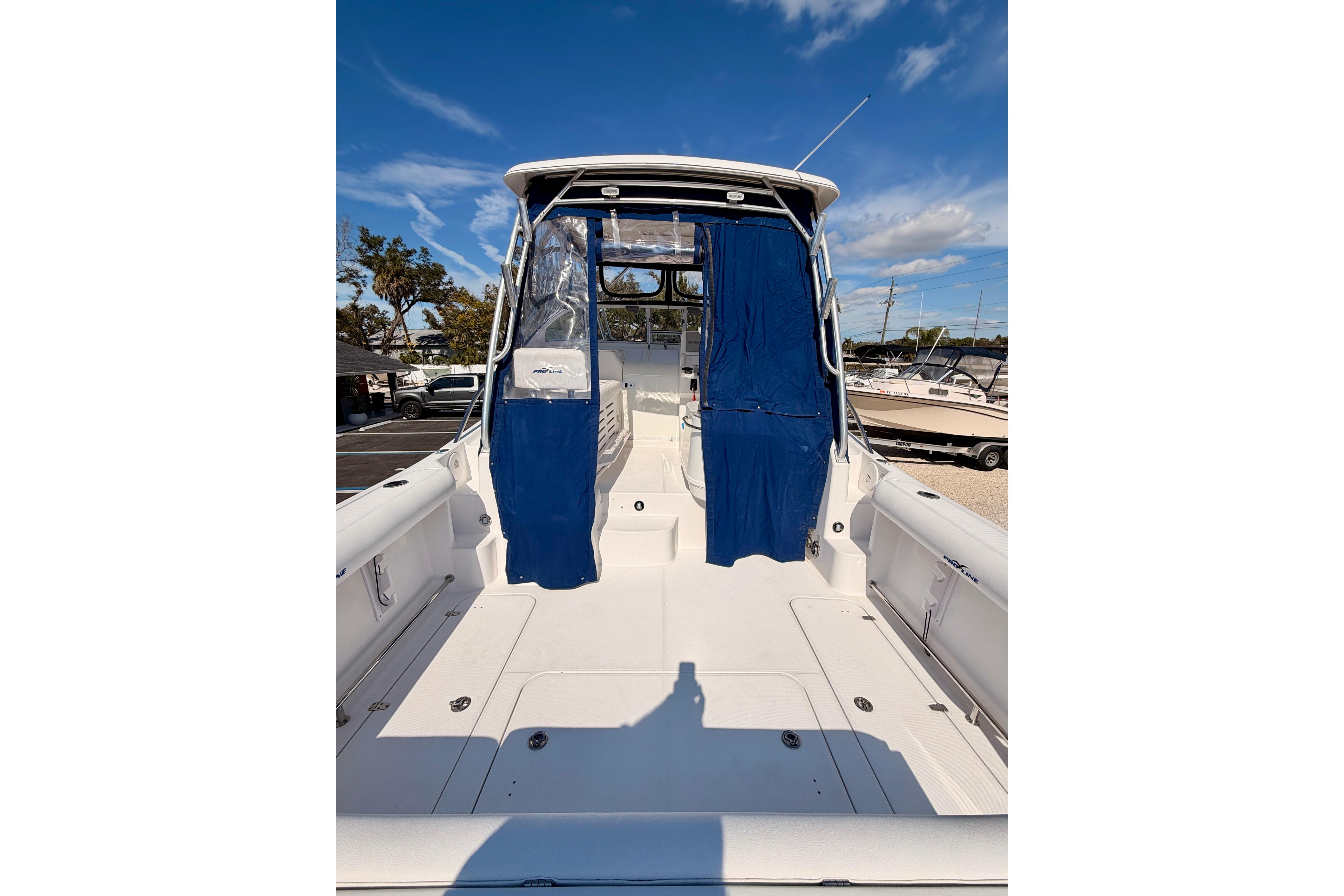 2007 Pro-Line 32 Express boat with blue canopy, docked under clear sky.