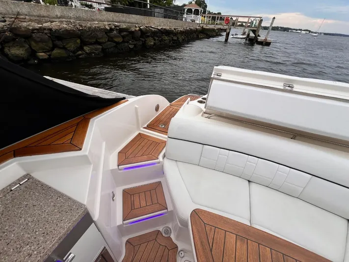  Yacht Photos Pics 2014 Sea Ray 350 SLX boat interior with wooden steps and seating by the water.