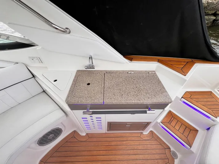  Yacht Photos Pics 2014 Sea Ray 350 SLX boat interior with kitchenette and wooden flooring.