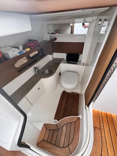  Yacht Photos Pics 2014 Sea Ray 350 SLX boat interior with sink, toilet, and wooden flooring.
