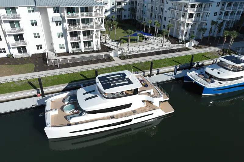  Yacht Photos Pics Aerial view of 2026 Granocean W-72 yacht docked near modern waterfront apartments.