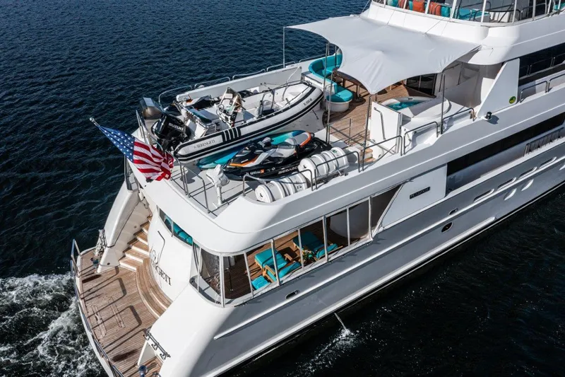 Serengeti Yacht Photos Pics Westport Flybridge 2002 yacht cruising on water, featuring upper deck with watercraft and American flag.