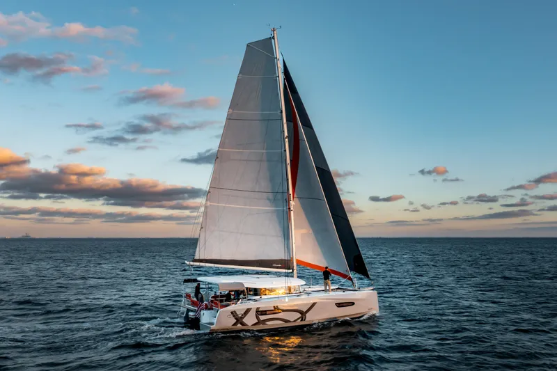  Yacht Photos Pics Sailing catamaran Excess 14, 2026 model, cruising at sunset on open sea.