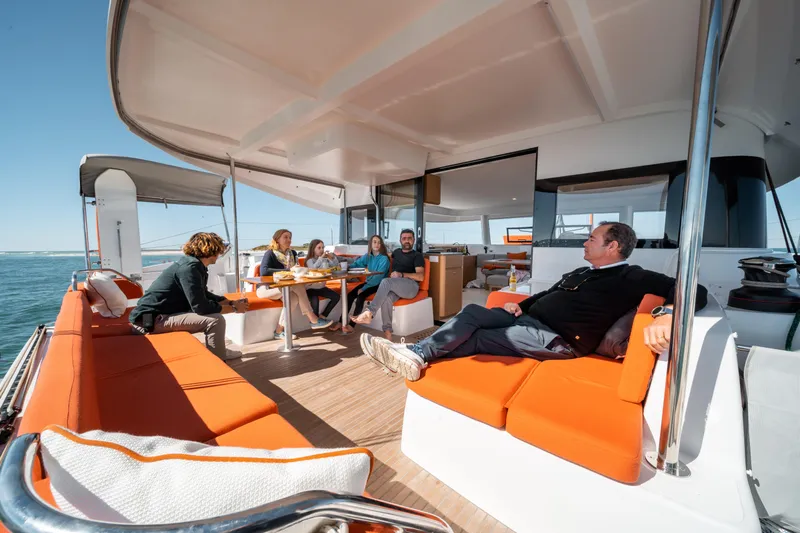  Yacht Photos Pics People relaxing on the deck of a 2026 Excess 14 catamaran, enjoying the ocean view.