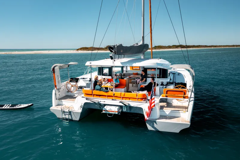  Yacht Photos Pics Luxury Excess 14 catamaran sailing in clear waters, 2026 model, with passengers enjoying the deck.
