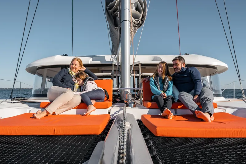  Yacht Photos Pics Family relaxing on 2026 Excess 14 catamaran, enjoying a sunny day at sea.
