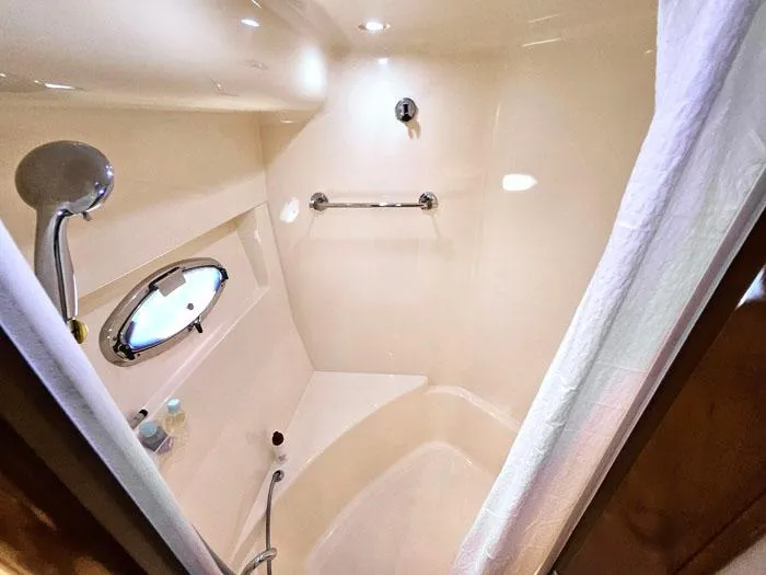  Yacht Photos Pics Shower area in 2004 Carver 560 Voyager PH yacht, featuring modern fixtures and porthole.
