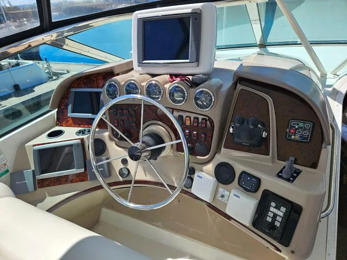  Yacht Photos Pics 2004 Carver 560 Voyager PH helm with steering wheel, gauges, and navigation screens.