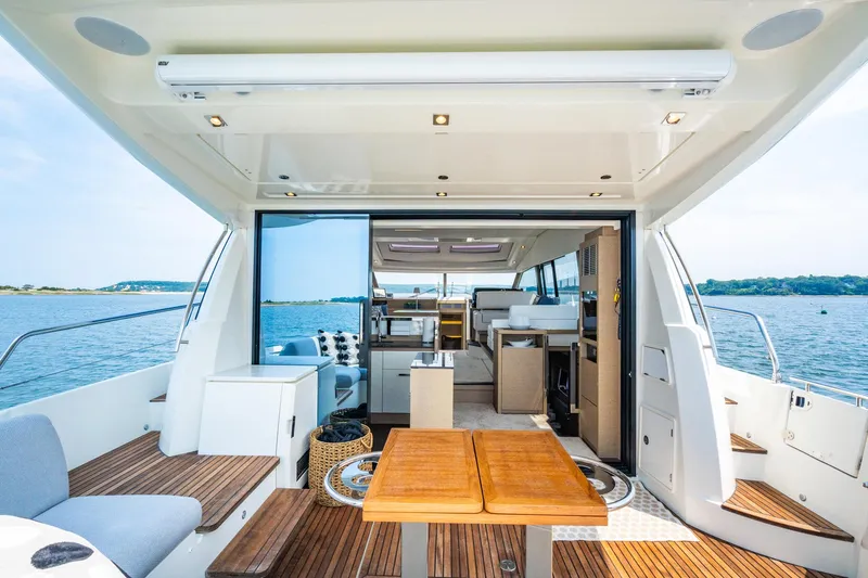 Yore Amuche Yacht Photos Pics Luxurious 2019 Prestige 520S yacht interior with open deck, wooden flooring, and scenic ocean view.