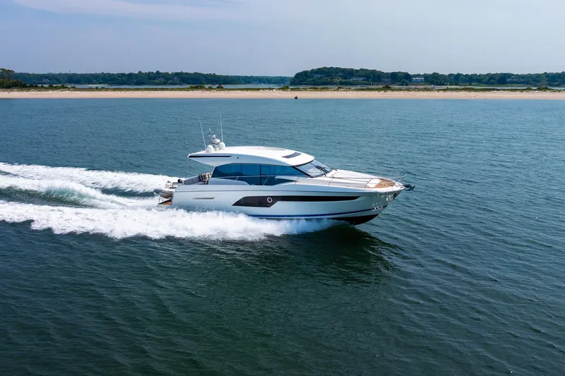 Yore Amuche Yacht Photos Pics 2019 Prestige 520S yacht cruising on open water near a sandy shoreline.