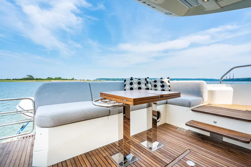 Yore Amuche Yacht Photos Pics Luxurious 2019 Prestige 520S yacht deck with seating, table, and scenic water view.
