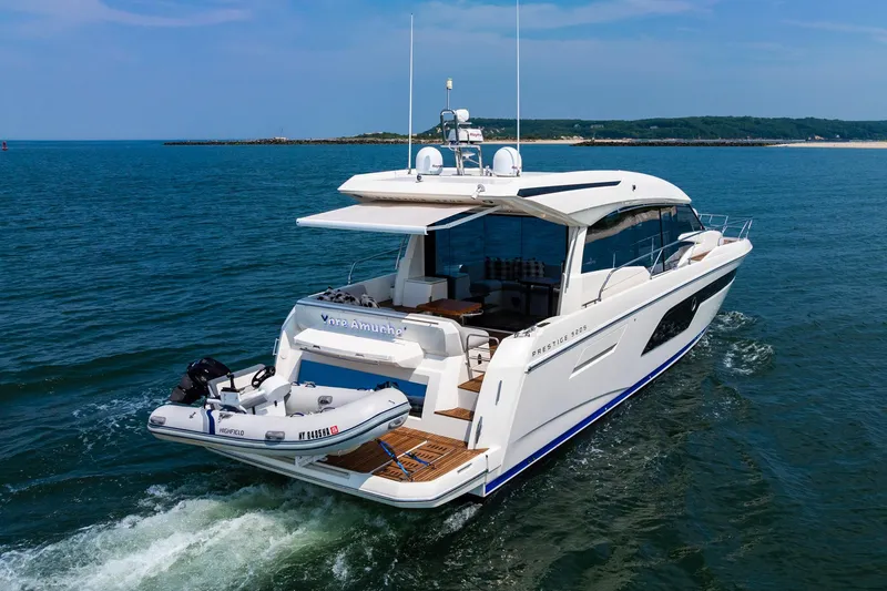 Yore Amuche Yacht Photos Pics 2019 Prestige 520S yacht cruising on open water with inflatable boat attached.