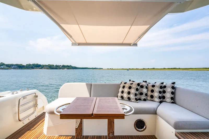 Yore Amuche Yacht Photos Pics Luxury 2019 Prestige 520S yacht deck with seating, table, and scenic water view.