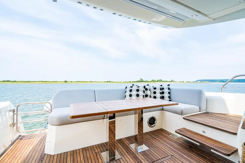 Yore Amuche Yacht Photos Pics Luxurious 2019 Prestige 520S yacht deck with seating, table, and scenic water view.