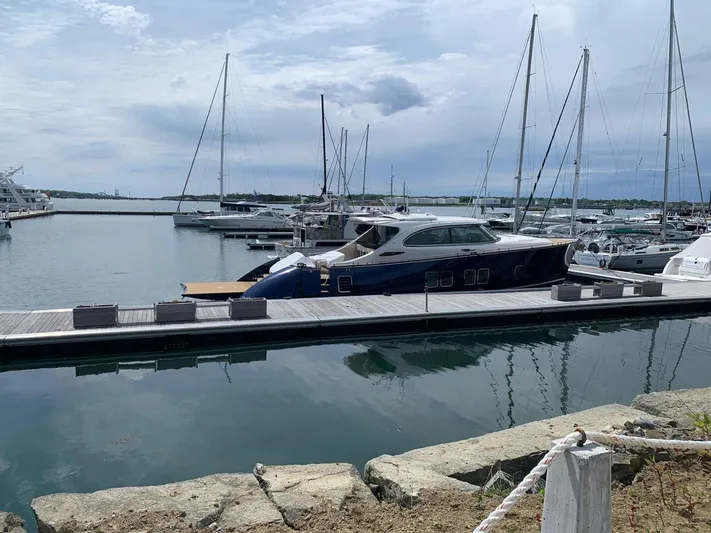 Tons Of Fun Yacht Photos Pics 2022 Zeelander Z72 yacht docked at a marina with sailboats in the background.