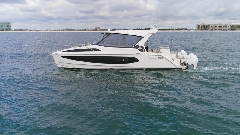  Yacht Photos Pics 2023 Aquila 36 Sport yacht cruising on open water under cloudy skies.