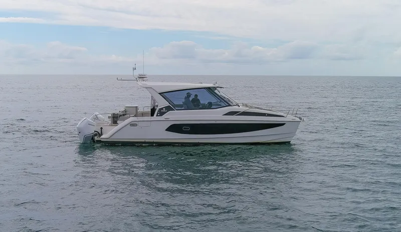  Yacht Photos Pics 2023 Aquila 36 Sport boat on calm ocean waters under a cloudy sky.