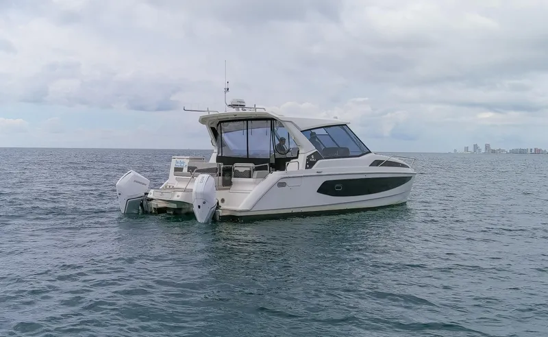  Yacht Photos Pics Aquila 36 Sport 2023 boat on open water, city skyline in background.