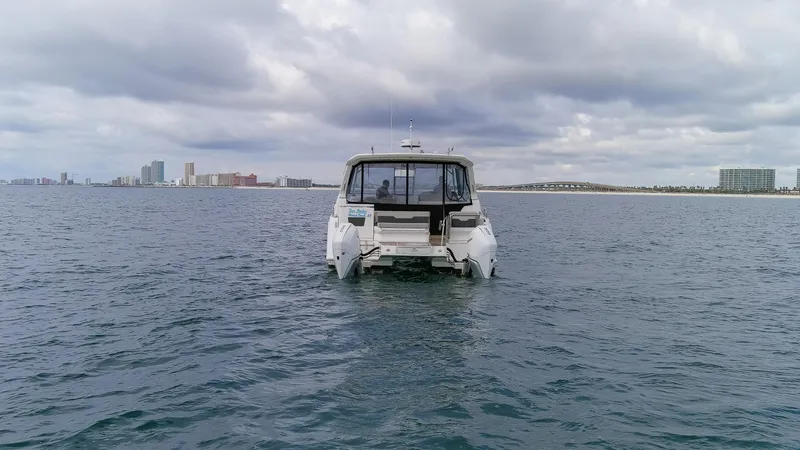  Yacht Photos Pics Aquila 36 Sport 2023 boat on open water with city skyline in background.