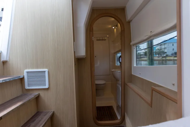  Yacht Photos Pics Interior of 2023 Aquila 36 Sport yacht, featuring a compact bathroom and wooden staircase.