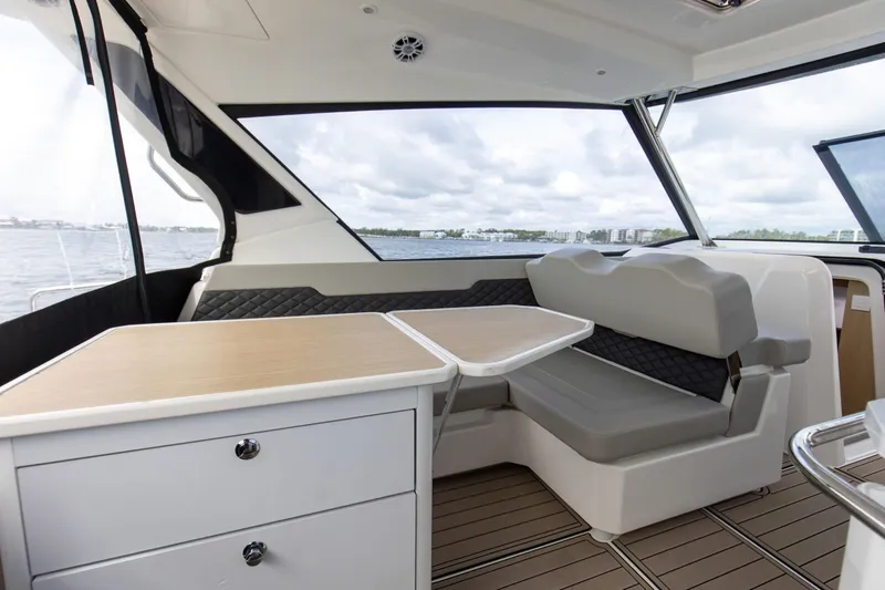 Yacht Photos Pics Interior of 2023 Aquila 36 Sport yacht with seating and table, overlooking water.