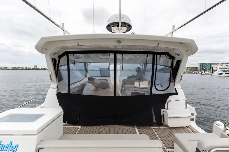  Yacht Photos Pics Aquila 36 Sport 2023 yacht with covered cockpit, docked on a calm waterfront.