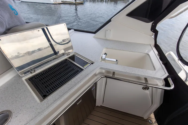  Yacht Photos Pics Aquila 36 Sport 2023 boat kitchenette with grill and sink, docked on water.