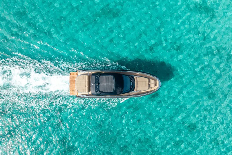V-adeus Yacht Photos Pics Aerial view of 2024 SACS Rebel 55 yacht cruising in clear turquoise waters.
