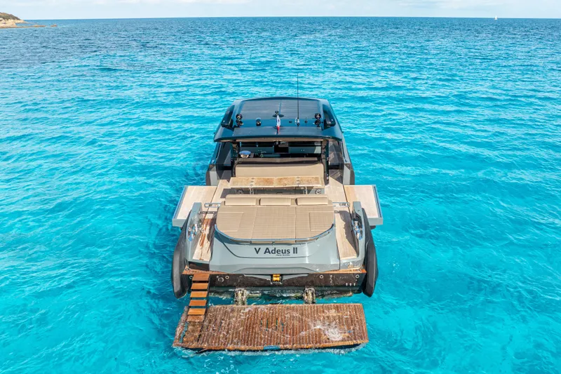 V-adeus Yacht Photos Pics 2024 SACS Rebel 55 yacht on clear blue ocean waters, rear view.