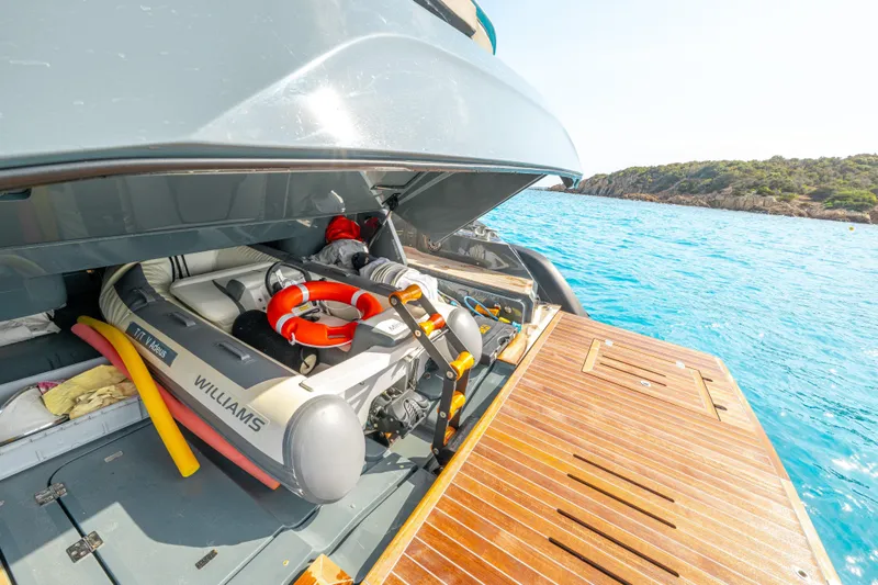 V-adeus Yacht Photos Pics 2024 SACS Rebel 55 yacht with tender storage, docked by clear blue waters.