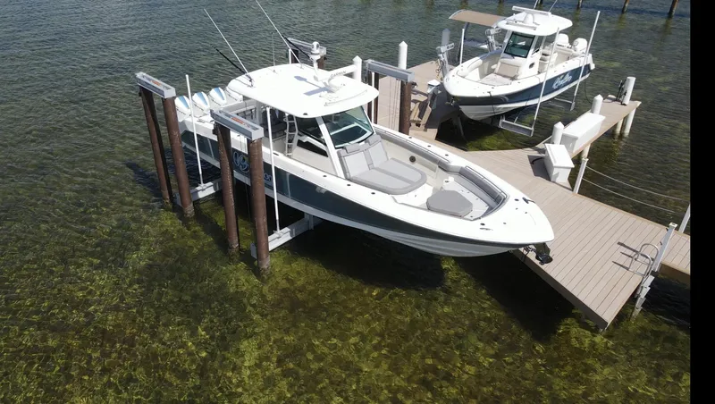  Yacht Photos Pics 2022 Boston Whaler 380 Outrage boat docked on clear water, aerial view.