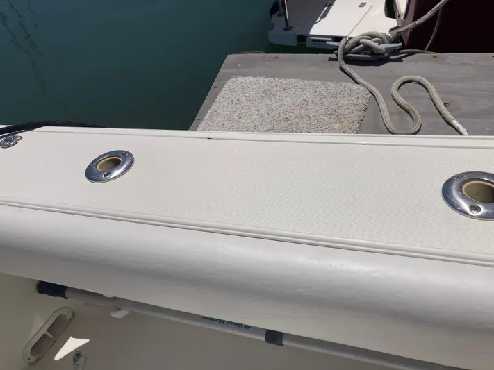 Alibi Yacht Photos Pics 2006 Rampage Express Offshore Tower boat deck with rod holders and docked rope.