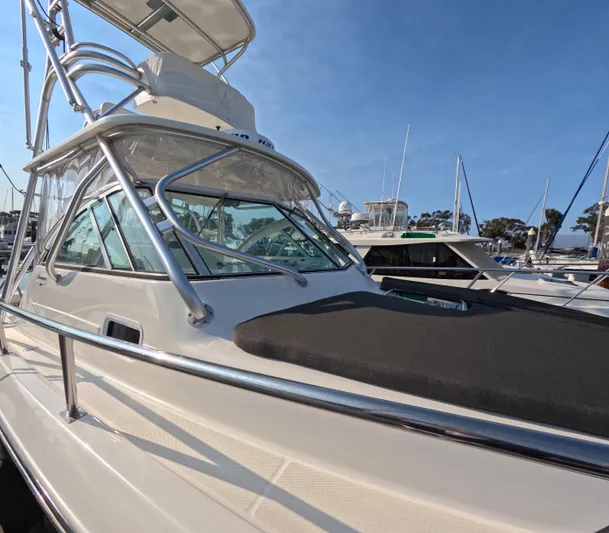 Alibi Yacht Photos Pics 2006 Rampage Express Offshore Tower boat docked in marina, featuring sleek design and sturdy railings.